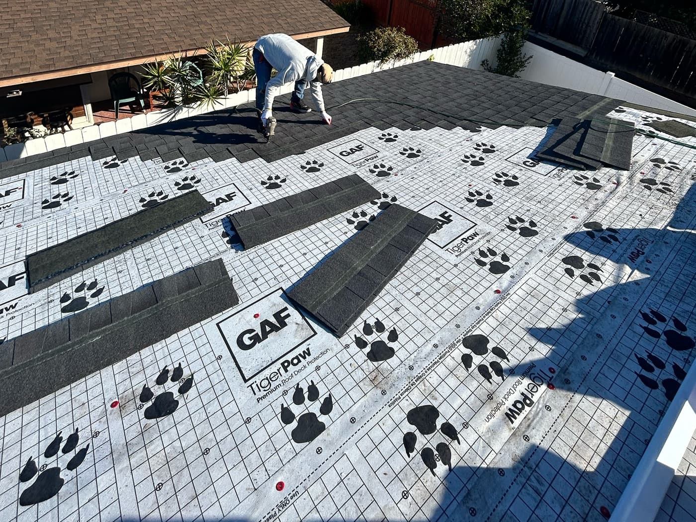TMC Roofing crew installing GAF Tiger Paw synthetic underlayment and architectural shingles