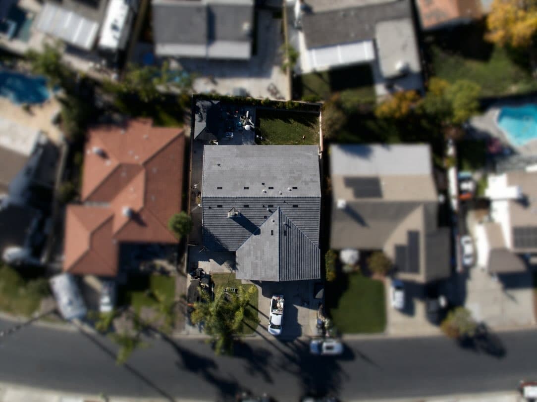 Top-down aerial view of a finished gray concrete-tile roof installed by TMC Roofing